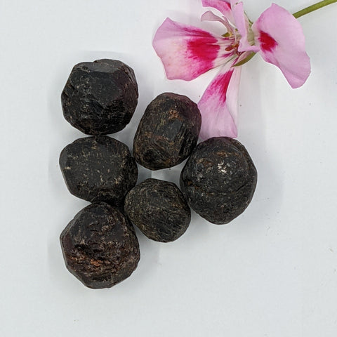 Almandine Tumbled Stones showcasing smooth, polished crystals in deep red hues, known for their ability to promote strength, emotional healing, and resilience.