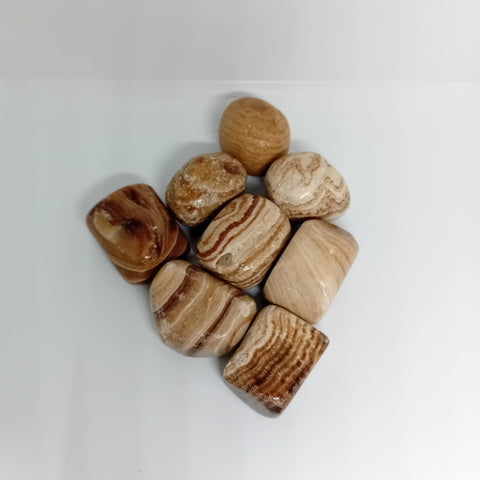 Aragonite Tumbled Stone showcasing smooth, polished crystals in earthy tones, known for their ability to enhance grounding, emotional stability, and reduce stress.