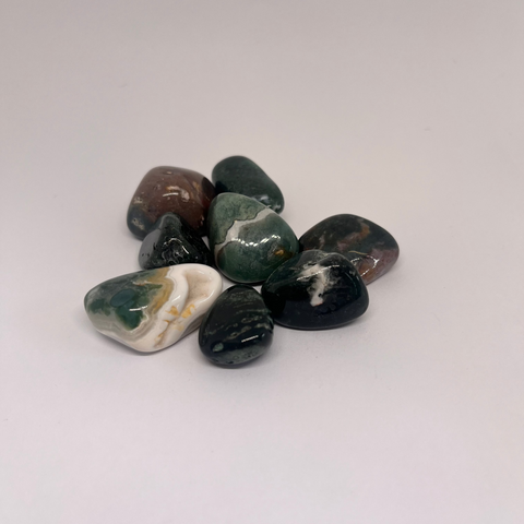 Bloodstone Tumbled Stones, rich green and red patterns with smooth polished surfaces, arranged in a group on a white background.