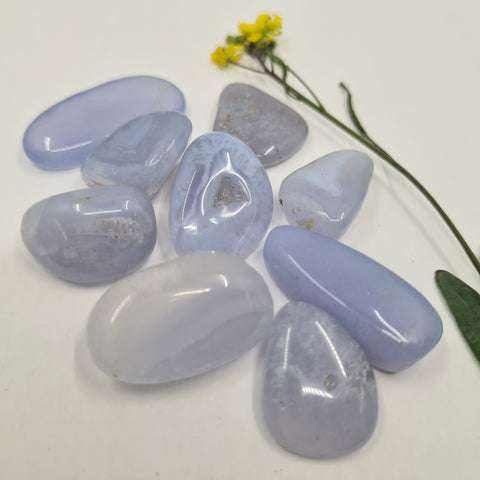 Blue Lace Agate Tumbled Stone showcasing smooth, polished crystals in light blue hues, known for their ability to promote calm, peaceful communication, and emotional healing.
