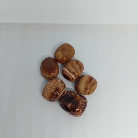 Coffee And Cream Calcite Tumbled Stones showcasing smooth, polished crystals in soft brown and cream hues, known for their ability to promote comfort, grounding, and emotional healing.