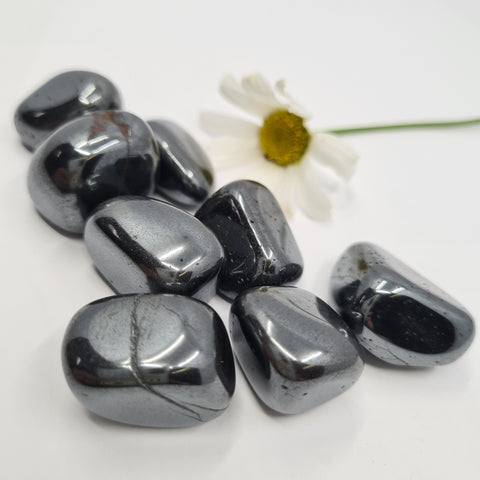 Hematite Tumbled Stone showcasing smooth, polished crystals in metallic gray hues, known for their ability to provide grounding, protection, and emotional stability.