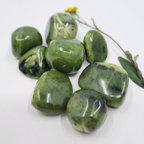 Jade Tumbled Stone showcasing smooth, polished crystals in green hues, known for their ability to attract abundance, promote healing, and encourage emotional balance.