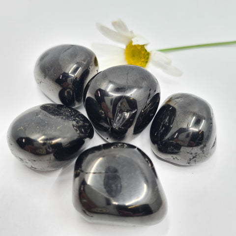 Jet Tumbled Stone showcasing smooth, polished crystals in deep black hues, known for their ability to absorb negative energy, protect the aura, and promote emotional healing.