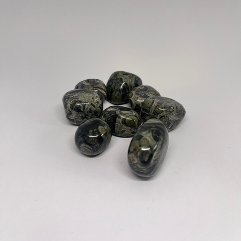 Kambaba Jasper Tumbled Stones displaying smooth, polished crystals with swirling green and black patterns, known for their grounding properties and ability to promote relaxation, inner peace, and emotional healing.