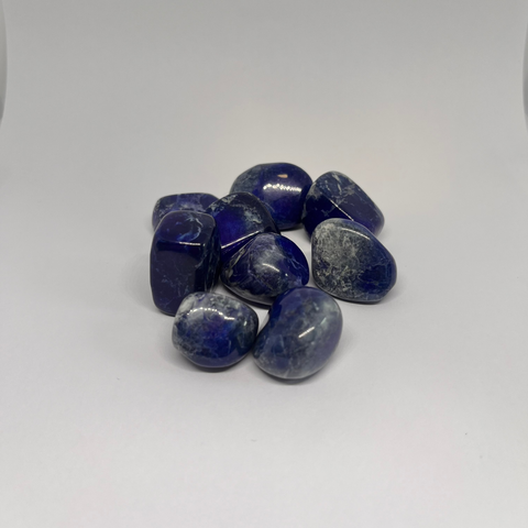 Lapis Lazuli Tumbled Stones featuring smooth, polished crystals in deep blue with golden flecks, known for their ability to enhance communication, wisdom, and spiritual awareness.