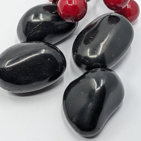 Large shungite tumbled stone on a white background, for grounding and energy clearing.