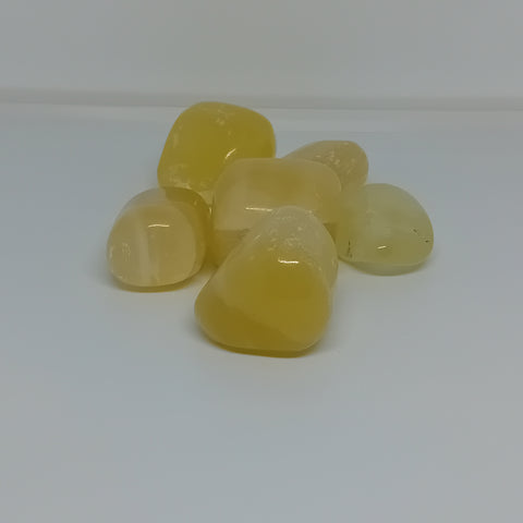 Lemon Calcite Tumbled Stones showcasing smooth, polished crystals in bright yellow hues, known for their ability to promote joy, confidence, and clarity.