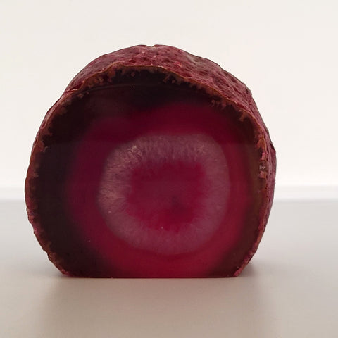 Polished Pink Agate Geode on white background, known to be a symbol of love and harmony