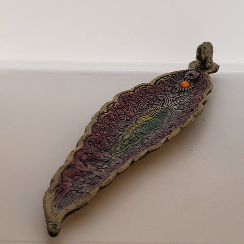 Pink metallic incense burner with gem and elephant detail on white background