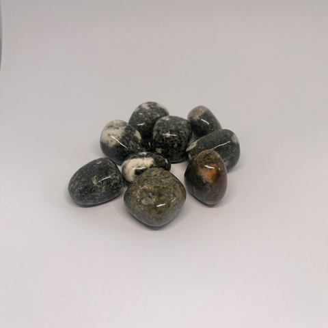 Preseli Bluestone Tumbled Stones showcasing smooth, polished crystals in green and gray hues with unique natural patterns, known for their ancient energy, grounding properties, and ability to enhance spiritual connection.