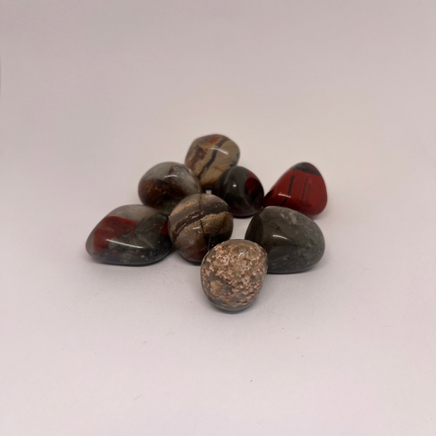 Seftonite Tumbled Stones displaying smooth, polished surfaces with a mix of red, brown, and grey hues, known for its grounding and healing properties.