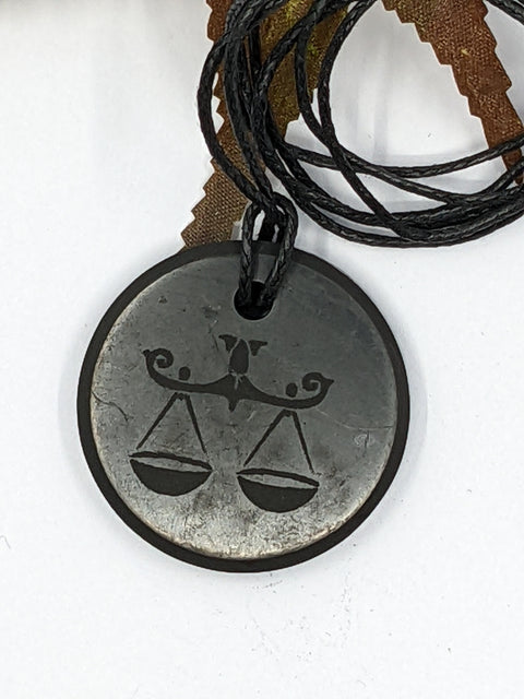 Shungite Libra zodiac sign pendant necklace on a white background, for balance and harmony.