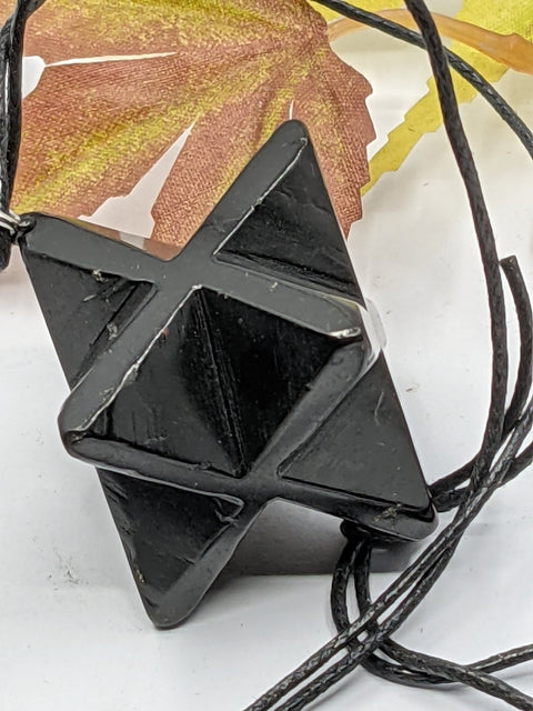 Shungite Merkaba star pendant necklace on a white background, featuring sacred geometry for balance and spiritual growth.