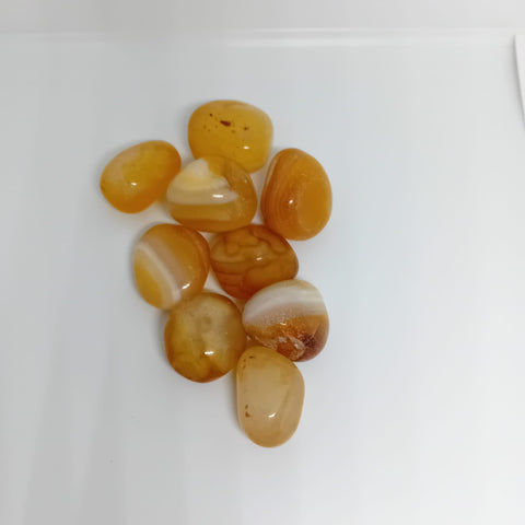 Yellow Agate Tumbled Stone showcasing smooth, polished crystals in golden yellow hues, known for their ability to boost confidence, provide balance, and support emotional healing.