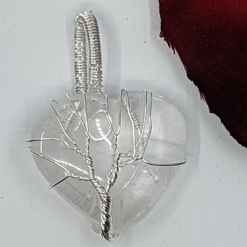 Clear Quartz Heart Pendant featuring a Tree of Life design on a white background.