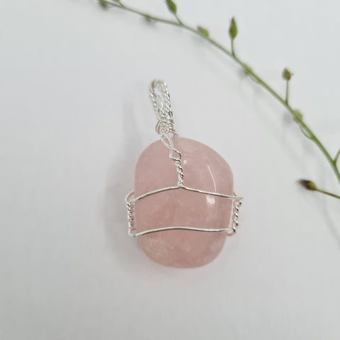 Rose Quartz Gemstone Pendant with a soft pink hue on a white background.