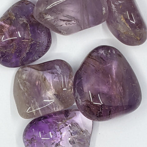 Ametrine Tumbled Stones showcasing smooth, polished crystals with a unique blend of purple amethyst and golden citrine hues, known for their ability to enhance clarity, balance energy, and promote spiritual growth.