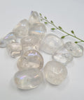 Angel Aura Quartz Tumbled Stones displaying smooth, polished crystals with a clear, iridescent finish, known for their ability to enhance spiritual connection, bring tranquility, and amplify energy.