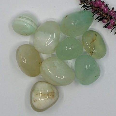 Aqua Onyx Tumbled Stones featuring smooth, polished crystals in soft pastel greens and blues, known for their calming energy and ability to promote emotional healing and clarity.