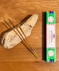 Satya Ayurveda Nag Champa Incense Sticks 15g box on a wooden background, crafted to promote balance and harmony.