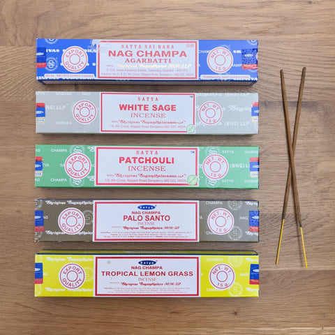 Satya Incense Best Seller Bundle showcasing Nag Champa Satya Incense, Satya White Sage, Satya Patchouli, Satya Palo Santo and Satya Tropical Lemongrass all laid flat on a wooden background.