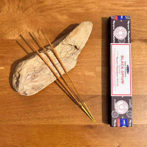 Satya Black Opium Incense Sticks 15g box on a wooden background, offering a deep and exotic fragrance.
