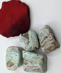 Caribbean Blue Calcite Tumbled Stones showcasing smooth, polished crystals with soft blue and tan hues, known for their calming properties and ability to enhance relaxation and emotional healing.