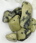 Chytha Serpentine Tumbled Stones displaying smooth, polished crystals in olive green with black veins, known for their grounding energy, healing properties, and ability to enhance spiritual growth.