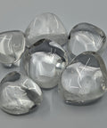 Clear Quartz Tumbled Stones displaying smooth, polished crystals with a transparent, glass-like appearance, known for amplifying energy, promoting clarity, and enhancing healing practices.