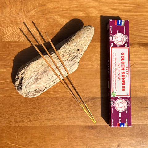 Satya Golden Sunrise Incense Sticks 15g box on a wooden background, offering a refreshing and rejuvenating scent.