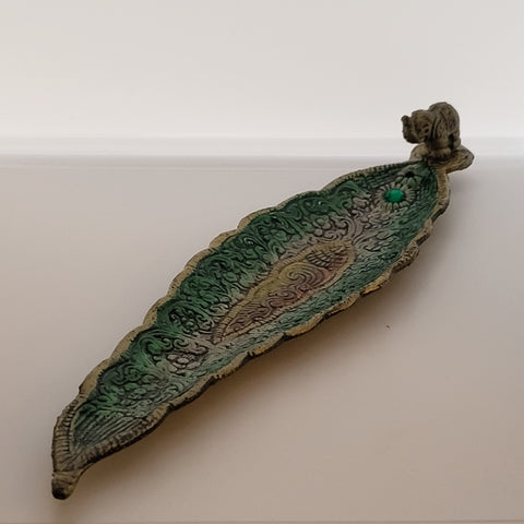 Green metallic incense burner with gem and elephant detail on white background