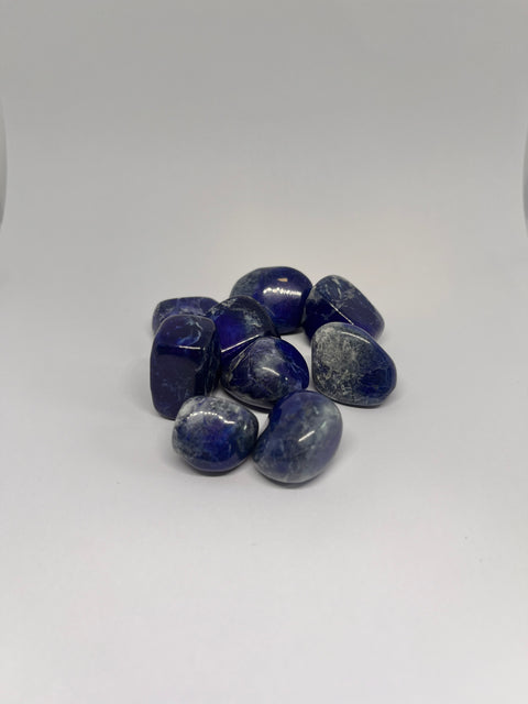 Lapis Lazuli Tumbled Stones featuring smooth, polished crystals in deep blue with golden flecks, known for their ability to enhance communication, wisdom, and spiritual awareness.