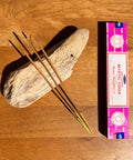 atya Mystic Yoga Nag Champa Incense Sticks 15g box on a wooden background, crafted to enhance yoga and meditation.