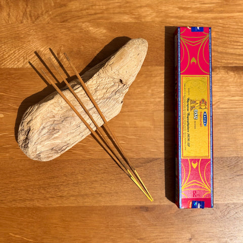 Satya Natural Rose Incense Sticks 15g box on a wooden background, with a gentle and timeless floral fragrance.