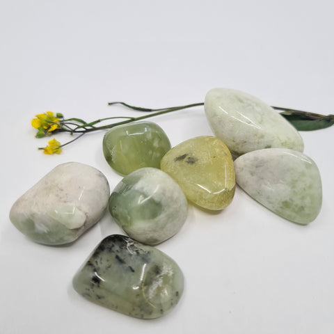 New Jade (Serpentine) Tumbled Stones showcasing smooth, polished crystals in soft green, yellow, and white hues, known for their ability to promote healing, spiritual growth, and energy clearing.