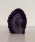 Polished Purple Agate Geode on white background, known for its ability to enhance intuition, spiritual awareness, and mental clarity