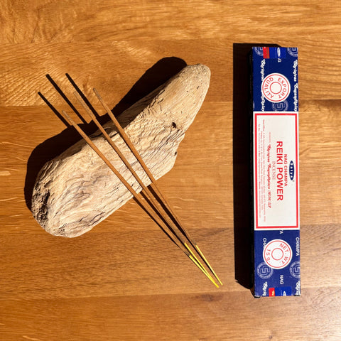 Satya Reiki Power Incense Sticks 15g box on a wooden background, known for facilitating energy healing practices.