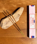 Satya Romance Incense Sticks 15g box on a wooden background, offering a warm and alluring fragrance for intimate settings.