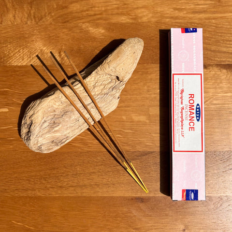 Satya Romance Incense Sticks 15g box on a wooden background, offering a warm and alluring fragrance for intimate settings.