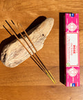 Satya Rose Incense Sticks 15g box on a wooden background, offering a classic and romantic floral fragrance.