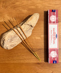 Satya Sacred Ritual Nag Champa Incense Sticks 15g box on a wooden background, perfect for elevating spiritual practices.