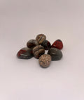 Seftonite Tumbled Stones displaying smooth, polished surfaces with a mix of red, brown, and grey hues, known for its grounding and healing properties.