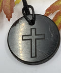 Shungite cross pendant necklace on a white background, combining spiritual protection and grounding energy.