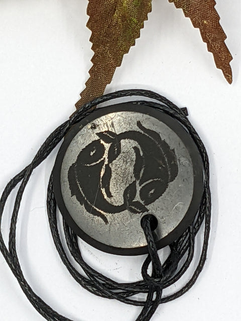 Shungite Pisces zodiac sign pendant necklace on a white background, for creativity and intuition.