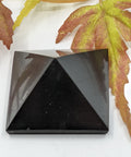 Shungite pyramid 3cm on a white background, for energy amplification and protection.