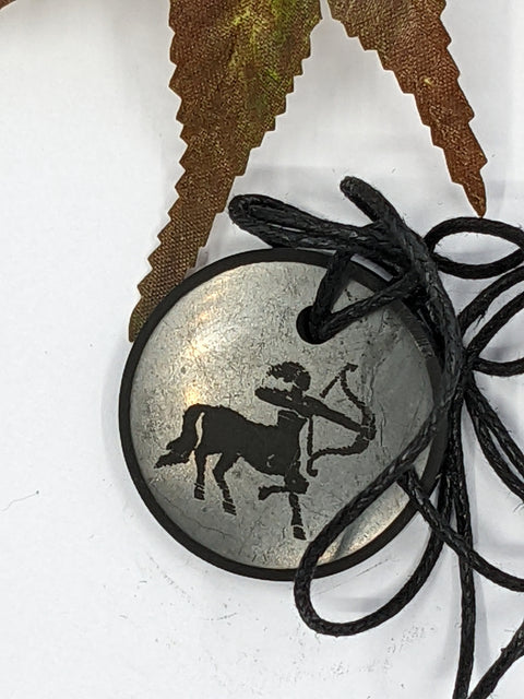 Shungite Sagittarius zodiac sign pendant necklace on a white background, for optimism and focus.