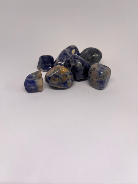 Sodalite Tumbled Stones featuring a mix of blue and white hues, with smooth polished surfaces, arranged in a group on a white background.