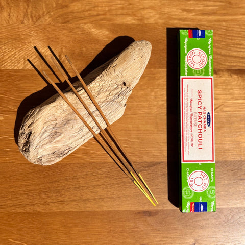 Satya Spicy Patchouli Incense Sticks 15g box on a wooden background, featuring a warm and rich fragrance.
