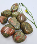 Unakite Tumbled Stones showcasing smooth, polished crystals in vibrant green and pink hues, known for their ability to promote emotional healing, balance, and personal growth.